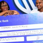 Sarah Nankumba, the Stanbic Acacia branch manager handing over a dummy cheque to Akugizibwe Annet Mbabazi, One of the lucky winners in the kyadouble with Supa Dupa campaign