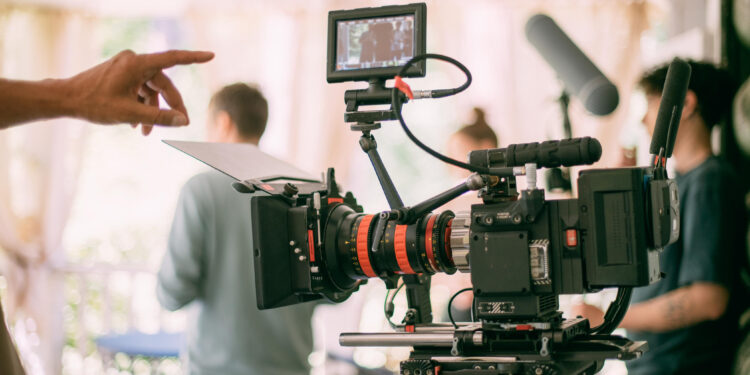 Professional cinema and video camera on the set. Shooting shift, lighting fixtures, shooting equipment and the team. Technique of modern filming and advertising.