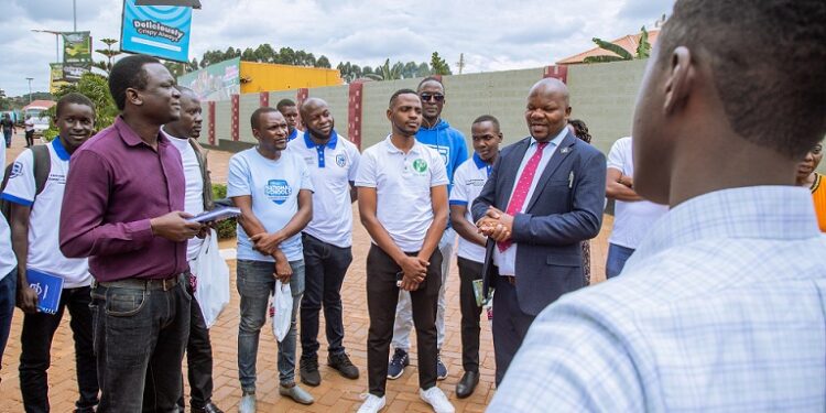 Business Fellowship category participants listen to one of the Stanbic NSC metors, Denis Ngabirano, the propriator of Sumz Crisps during the field trip