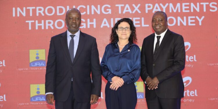 L-R: Odong James, the Ass. Commissioner, IT Dept. at URA, Polla Kotze, the Head of Investment Banking and transaction banking at Stanbic Bank, and Japheth Aritho, Managing Director of Airtel Mobile Commerce Uganda, pose for a photo during the event in Kampala.